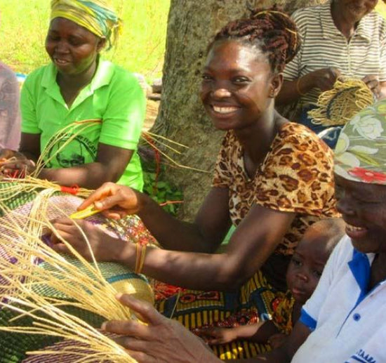 Woman smiling while weaving basket