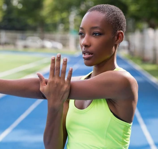 person standing on athletics track stretching