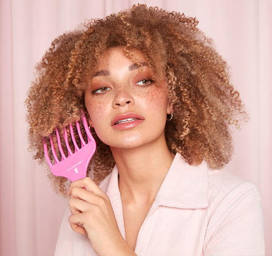 Combing afro with pink comb